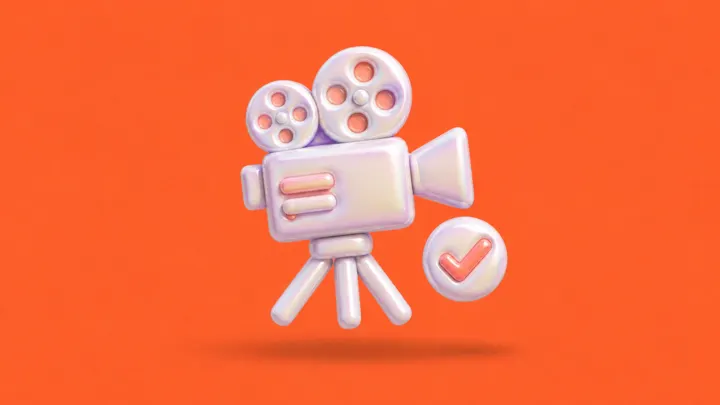 Uma câmera de cinema inflável sobre tripé, com um selo redondo de visto ao lado, sobre fundo laranja.