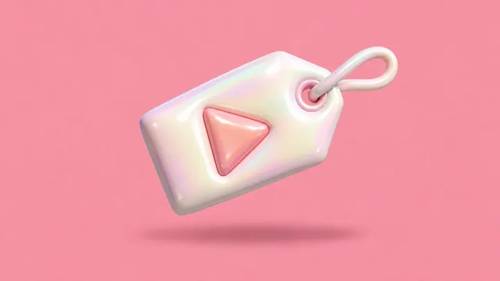 Uma etiqueta de preço inflável rosa com um botão de play em relevo, sobre fundo rosa.
