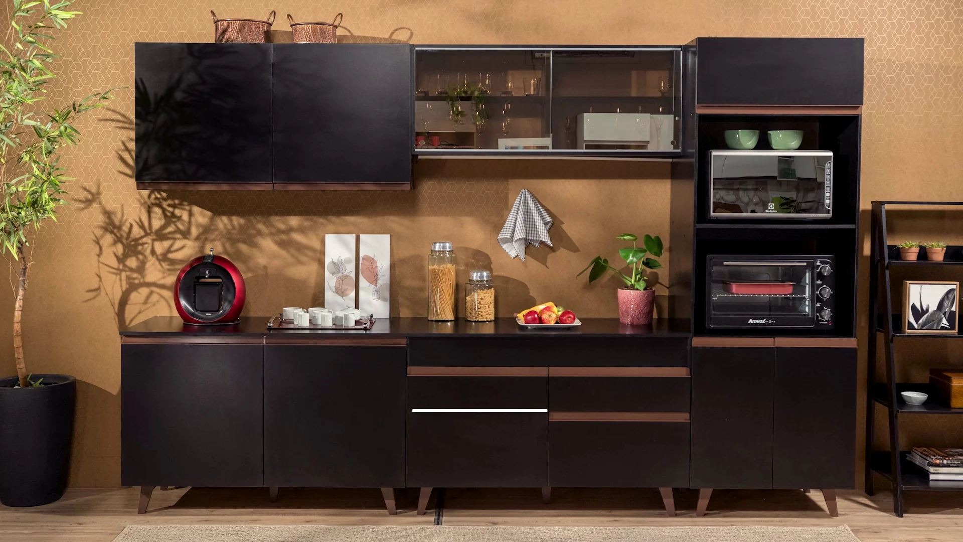 Composição de cozinha Madesa em preto e madeira contra parede terracota, com aéreos de vidro, torre de forno e micro-ondas e objetos de decoração.